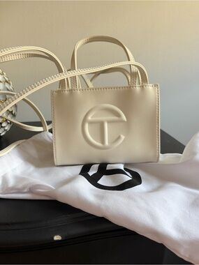 White mini telfar bag. With duster bag.